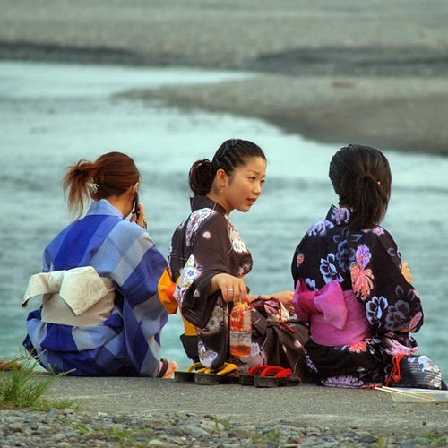 Three girls wearing yukata at a beach-side fireworks display in Shizuoka City