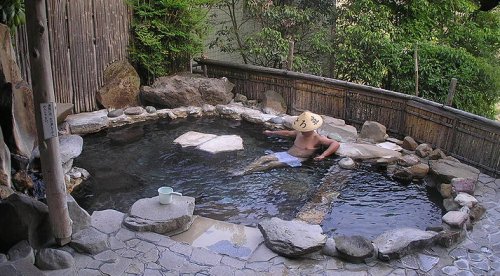A man bathing in a rotenburo
