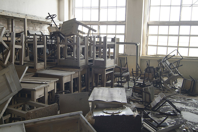 Desk and chairs stacked up in a classroom at Gunkanjima
