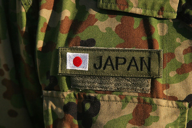 A close up of a the Japan flag on a Japanese Ground Self Defence Force camouflage-patterned uniform