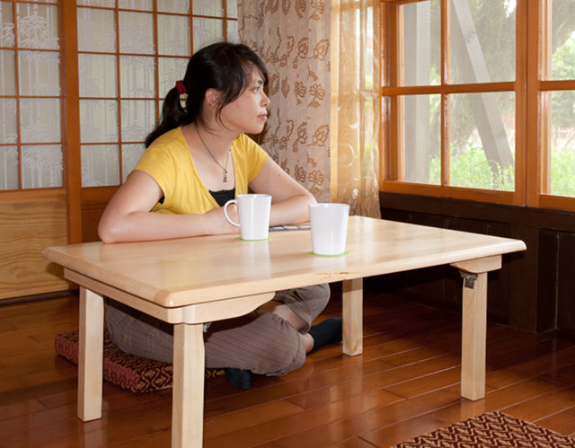 A woman sitting cross-legged at a table
