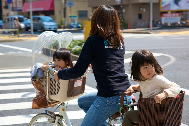 A mum and her two kids, all riding on one bike in Tokyo, Japan