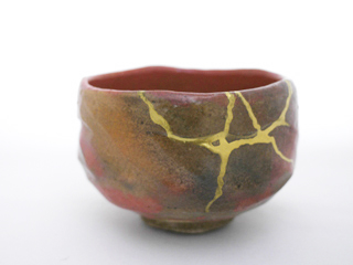 A Kichizaemon Raku teacup that has been broken into pieces and repaired with kintsugi.