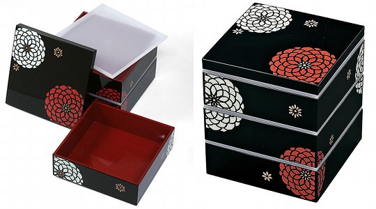 A Japanese lunch box with three tiers and traditional flower decoration