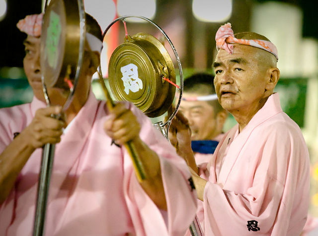 Men dressed in pink yukata playing kane bells at Koenji Awaodori