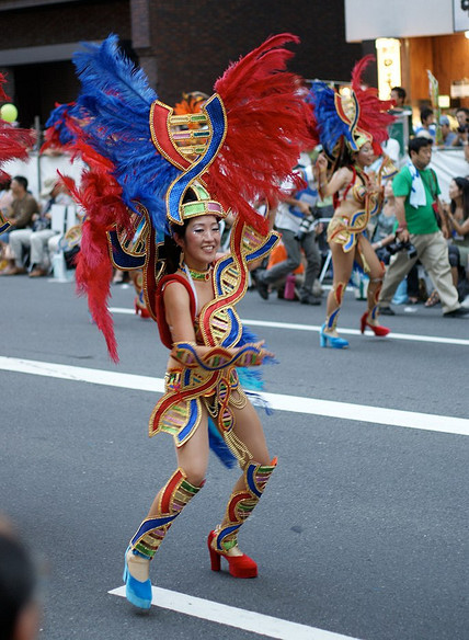 Two samba dancers with giant red and blue feathered headdresses