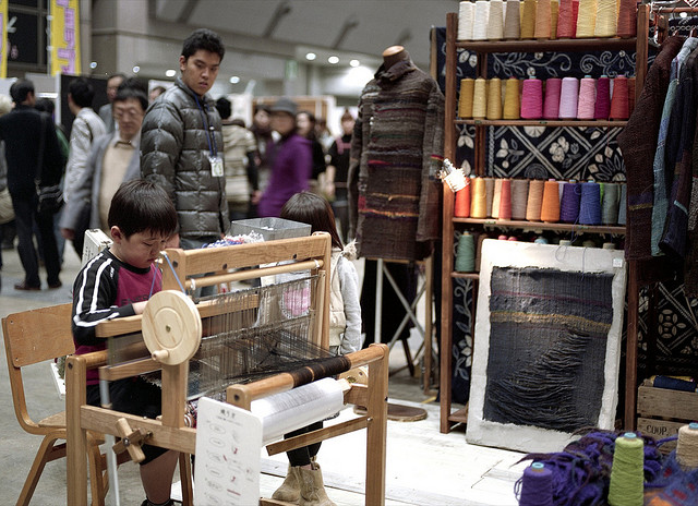 A boy weaves textile art by hand at Design Festa in Tokyo
