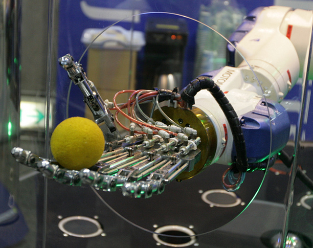A robot arm and hand holding a ball