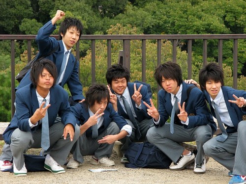 Six boys in school uniforms, and with matching hairstyles pose for a photo