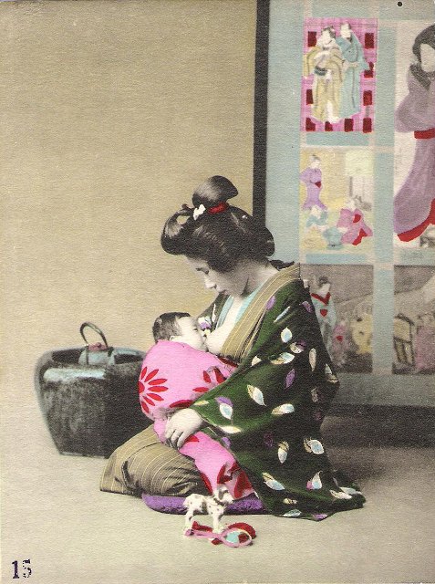 A woman in a kimono breast-feeding her baby