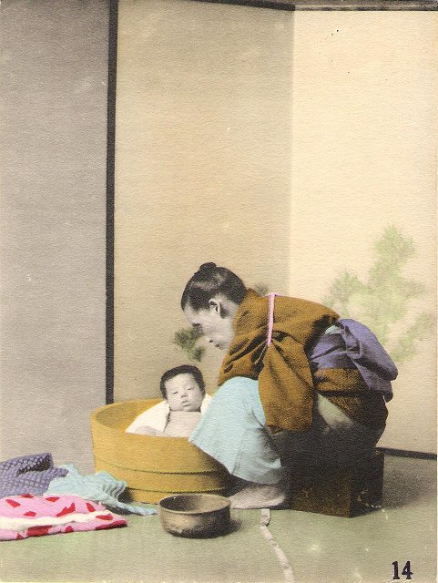 A Japanese midwife gives the first bath to a newly born baby