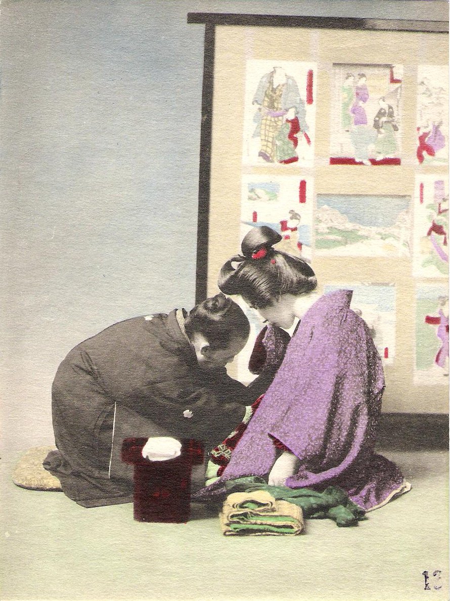 A midwife tying a band round a pregnant Japanese woman’s hips