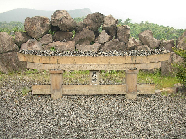 A shrine tori gate almost totally buried by a volcanic eruption